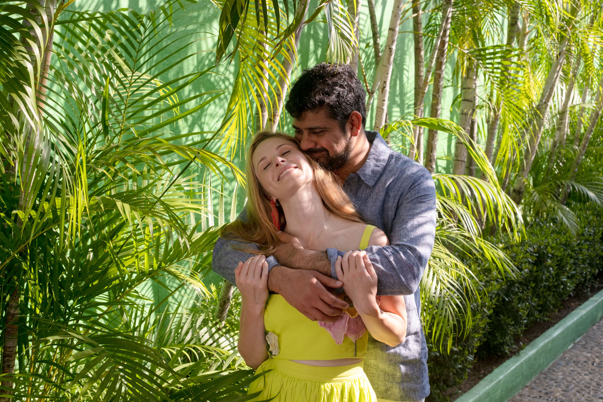 Zoe and Vik embracing in greenery